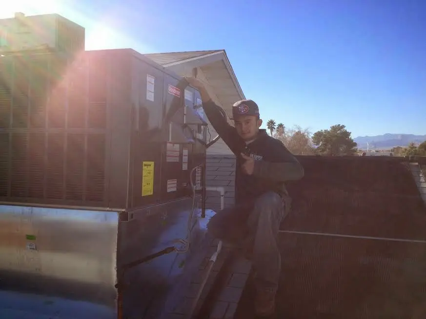 HVAC technician performing Air Duct Repair on a rooftop unit in Mineola
